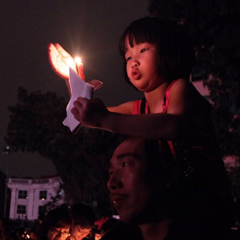 Ein Mädchen hält während der "Earth Hour" eine Kerze hoch.